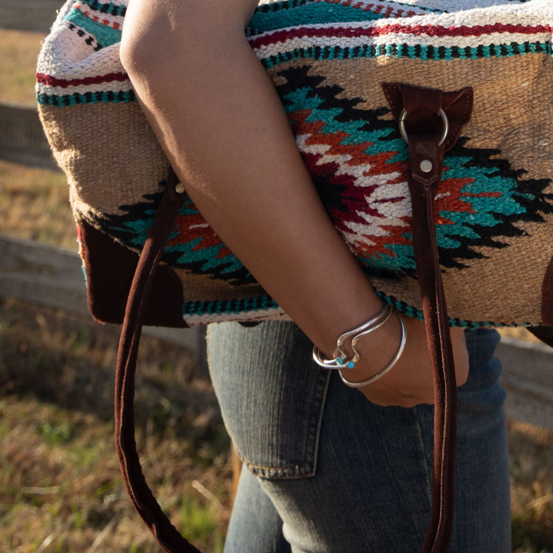 Adventurer Boho Bag Original Weekender Bag held by woman on her side outside wearing turquoise spirit cuffs