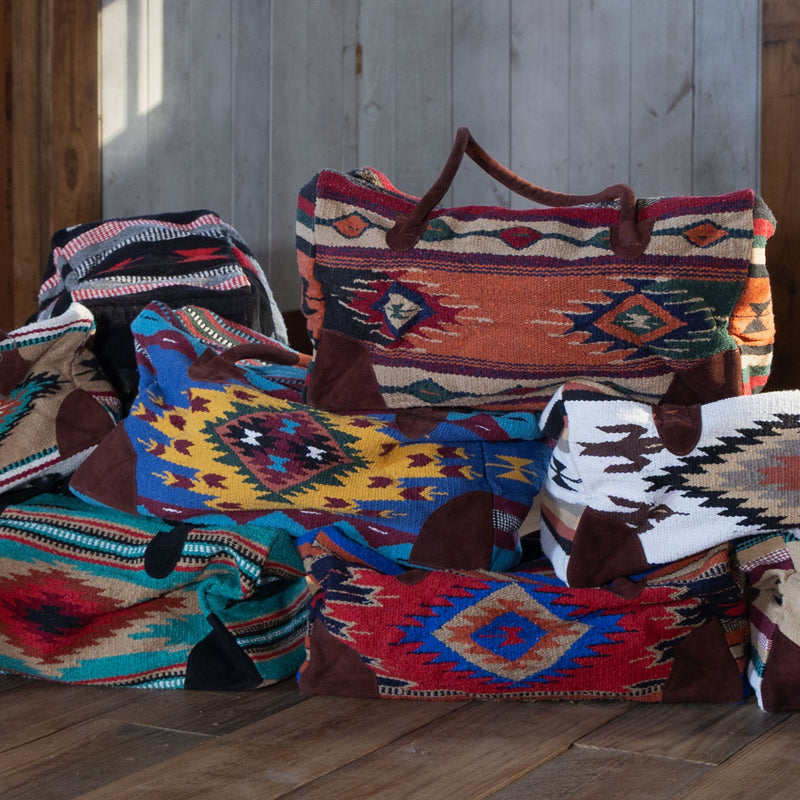 Byron Bay Boho Weekender Bag Kilim Stacked on other Weekender Bags on wood floor