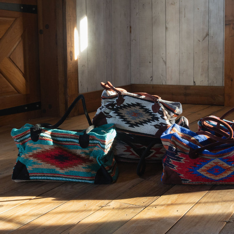 Byron Bay Boho Weekender Bag Navajo on wood floor with other weekender bags 