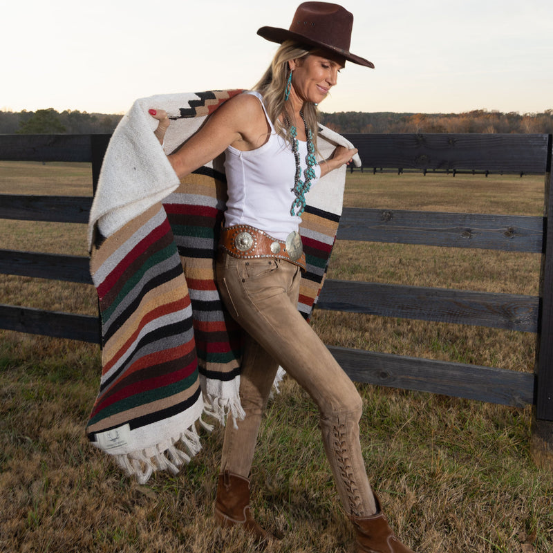 The Blue Tide Squash Blossom Necklace Worn by Founder Silvia Saey with Fence in the countryside