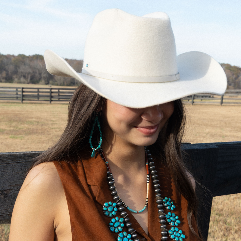 Three Realms Bone Necklace on body woman leaning against fence outside